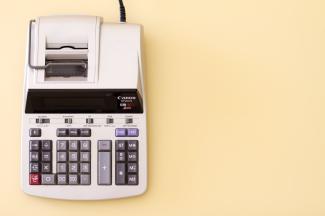 Ten key accounting calculator on a soft yellow desk